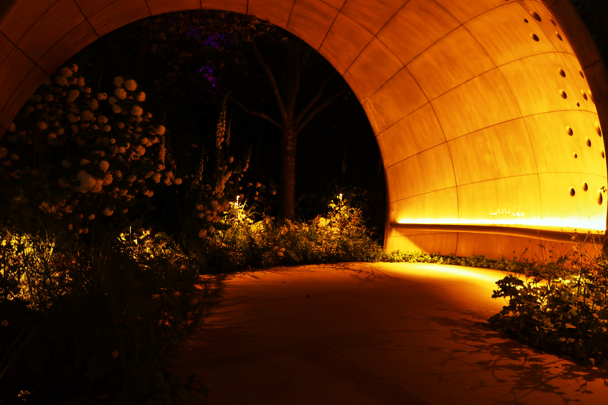2300K LED strip by Phos Lighting tracing the underside of the sculptural hand-rill in the Parkinson's UK garden, casting a warm candlelit glow